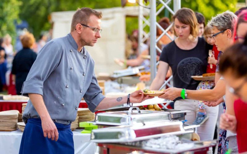 Ein Gastronom gibt Essen auf einem Fest aus
